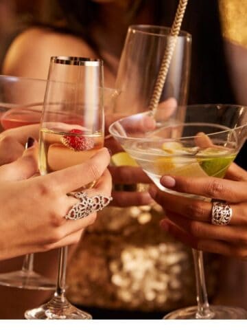 four hands putting wine glasses together
