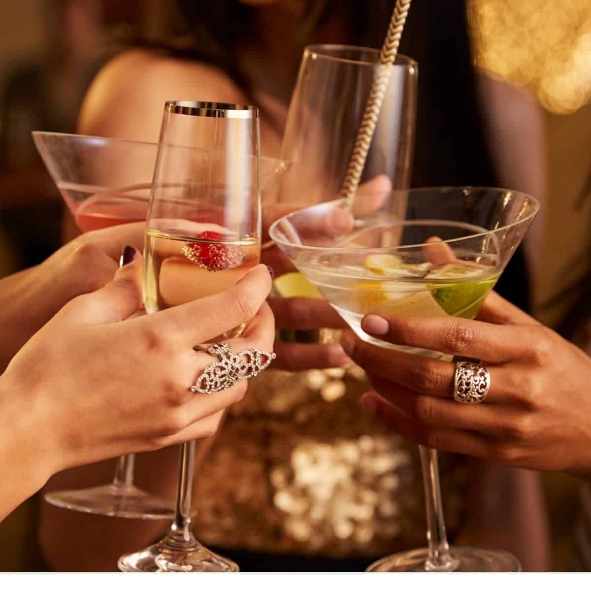 four hands putting wine glasses together