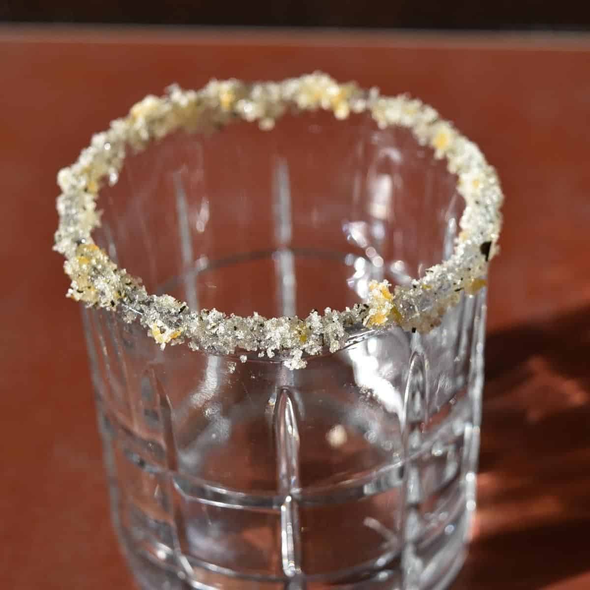 Rosemary and orange rimming sugar on a highball glass.