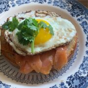 toast with smoked paprika mayo, salmon, and an egg on a blue plate