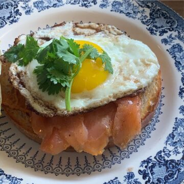 toast with smoked paprika mayo, salmon, and an egg on a blue plate