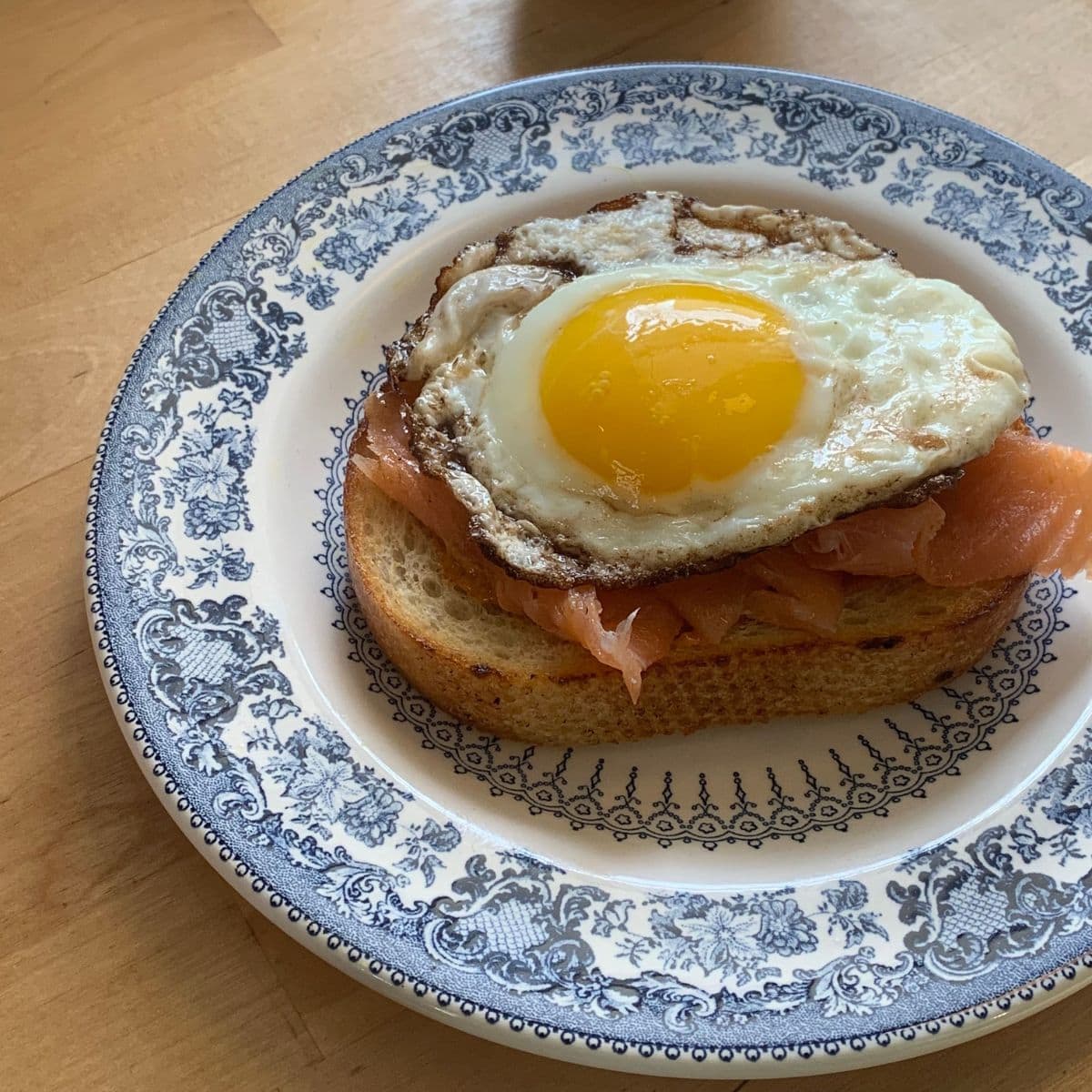 toast with smoked paprika mayo, salmon, and an egg on a plate