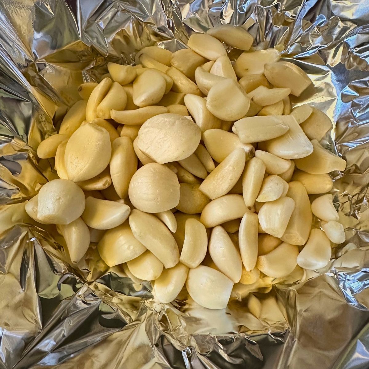 Peeled raw garlic cloves on foil