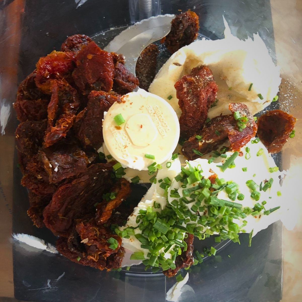 Sundried tomatoes, cream cheese, chives, and spices in a food processor