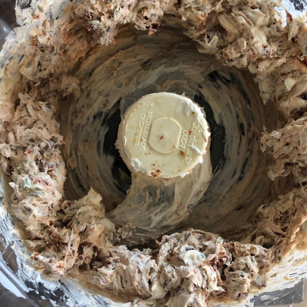 Sundried tomato schmear ingredients in a food processor, fully blended.