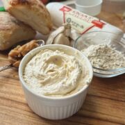 Roasted garlic and goat cheese spread and ingredients on a cutting board.