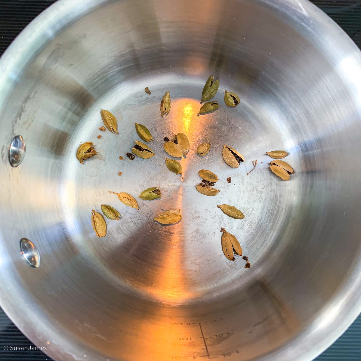 cardamom pods toasting in a small saucepot