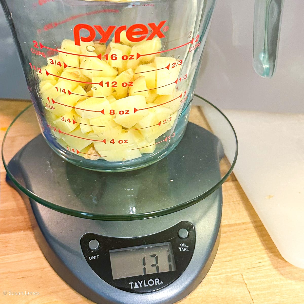 130 grams diced ginger in a measuring cup on a scale