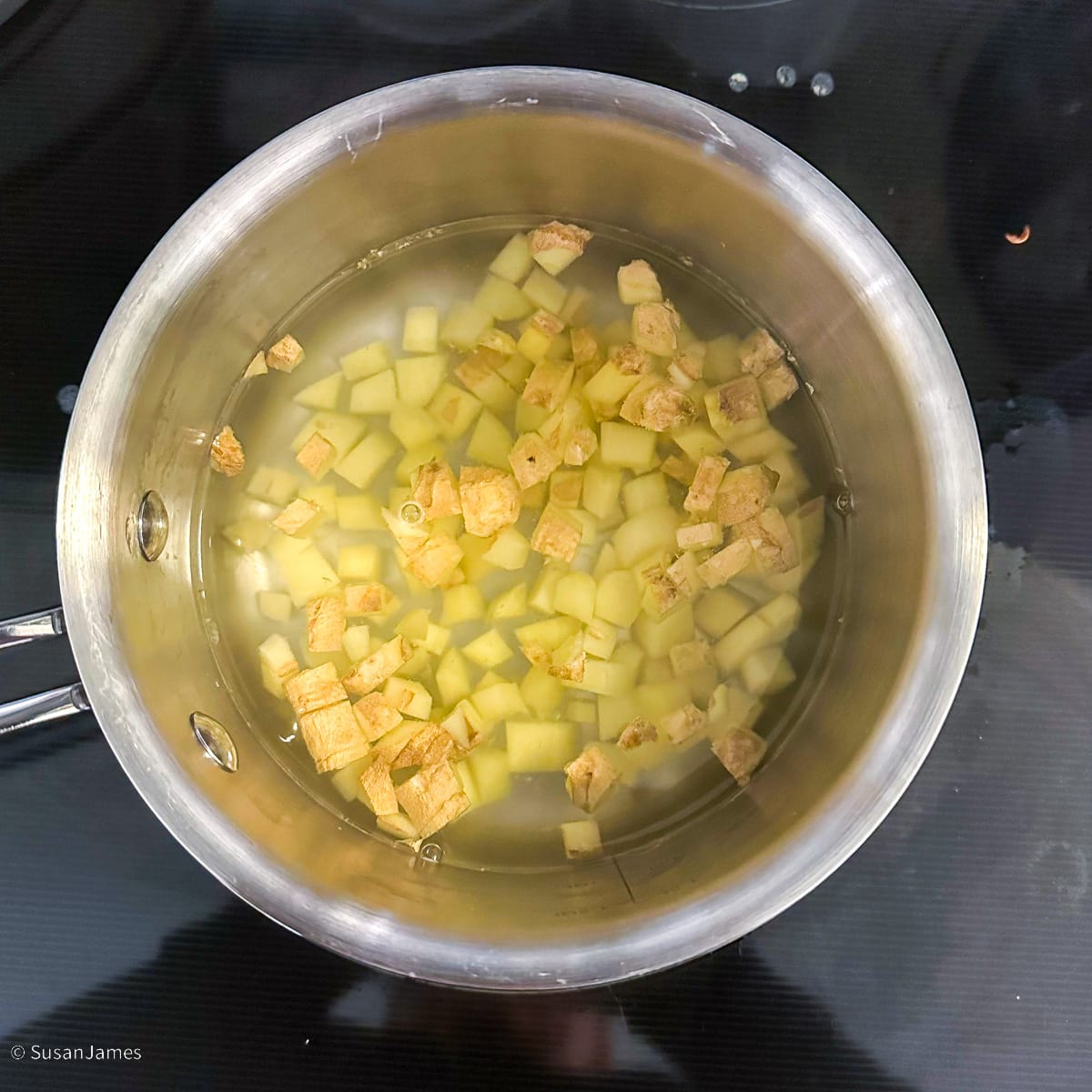 diced ginger simmering in a small saucepot