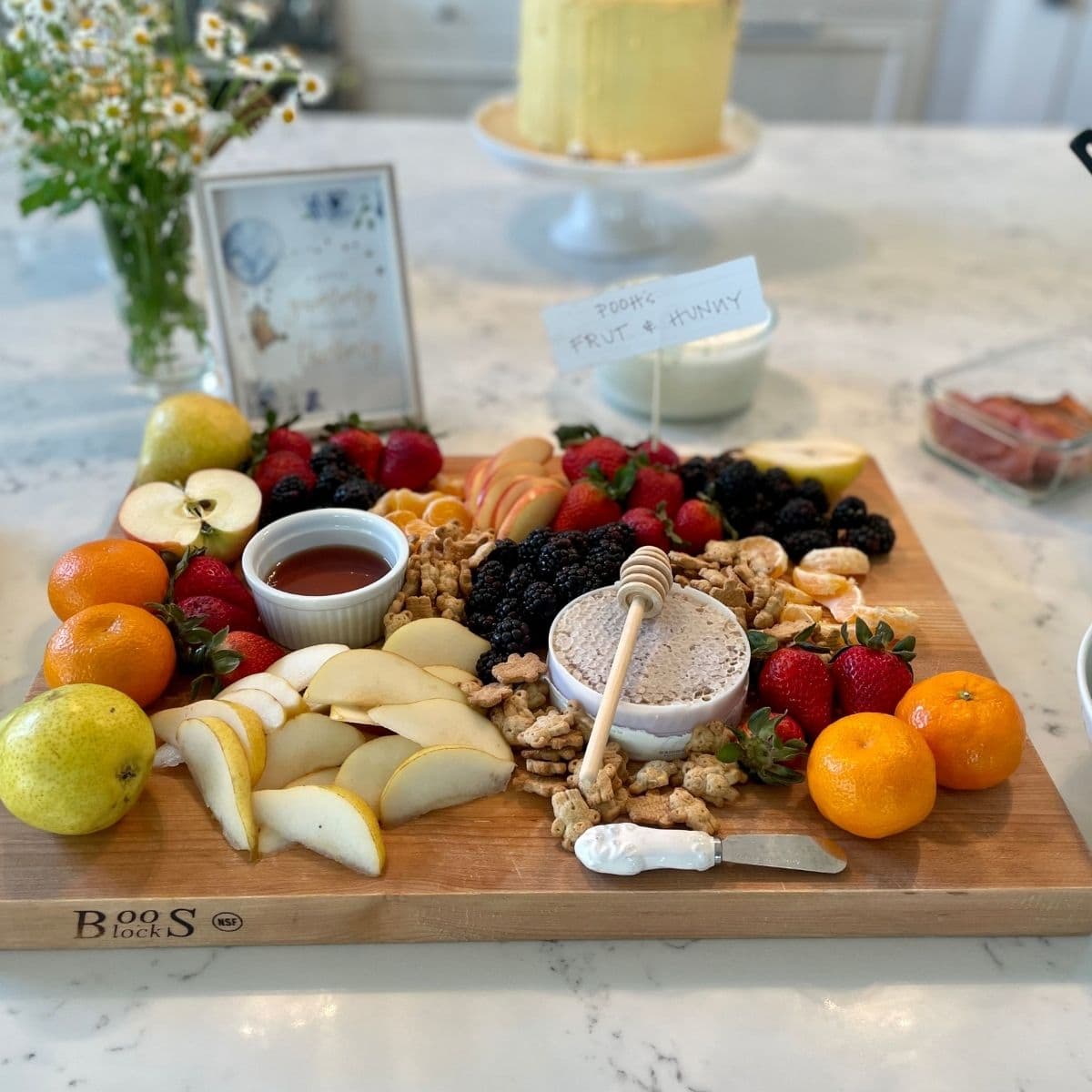 A charcuterie board with fruit and honeycomb.