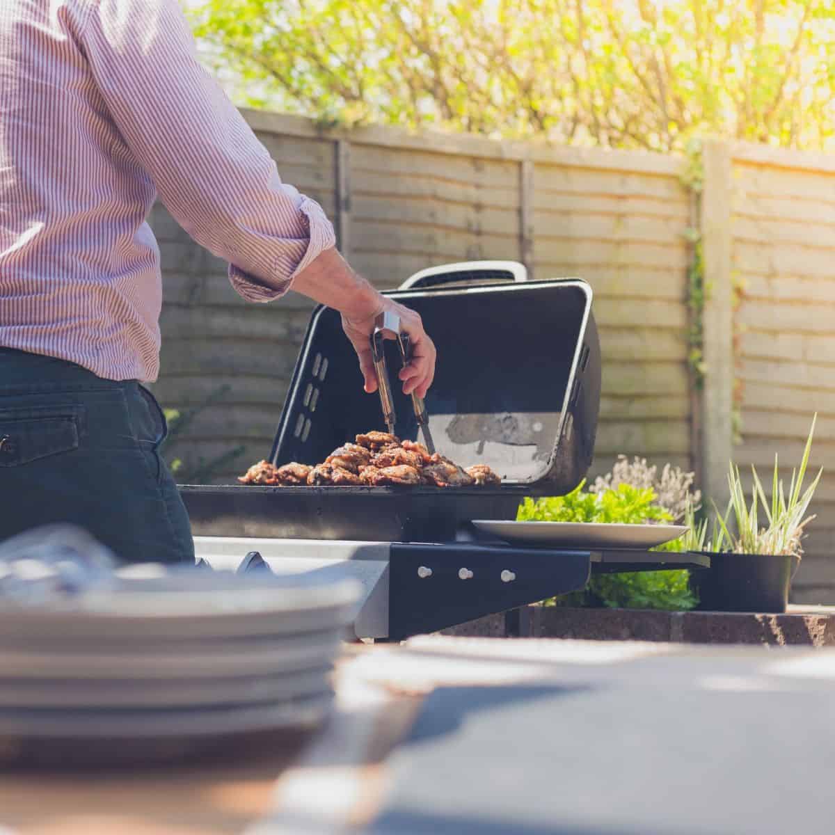 Man at a bbq in a backyard.
